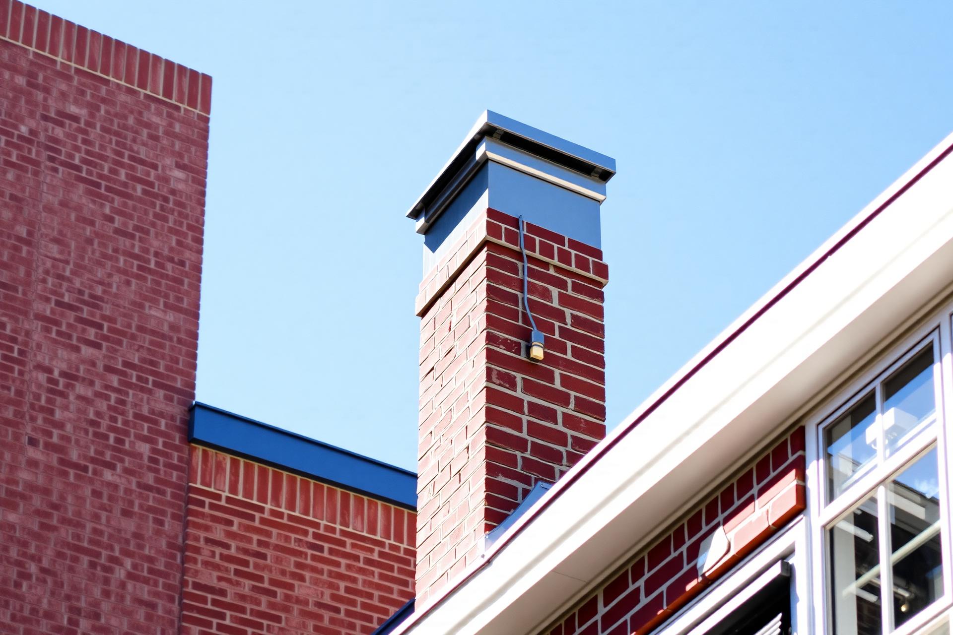 Brick chimney against a bright blue sky on a DC rooftop